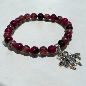 A beautifully crafted pink beaded bracelet featuring a delicate moth charm 🦋